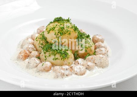 Patate giovani con polpette ed erbe su un piatto bianco Foto Stock