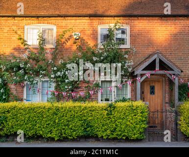 Sole, fiori e conigliamenti di mattina presto su un cottage a Stewkley, Buckinghamshire, Inghilterra Foto Stock