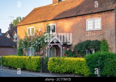 Sole, fiori e conigliamenti di mattina presto su un cottage a Stewkley, Buckinghamshire, Inghilterra Foto Stock