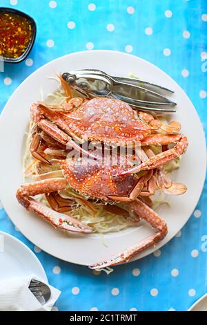 Due granchi appena cotti sul piatto bianco serviti con cavolo bianco Foto Stock