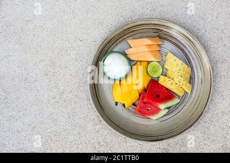 Piatto di frutta con anguria, mango, ananas, lime, melone e icecream Foto Stock