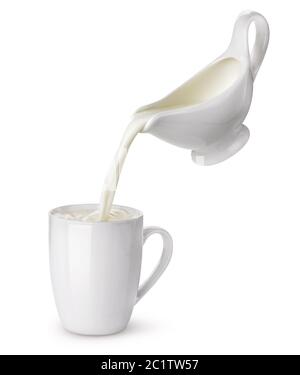 Versare la crema da creamer in tazza con splash isolati su sfondo bianco, il flusso di latte Foto Stock