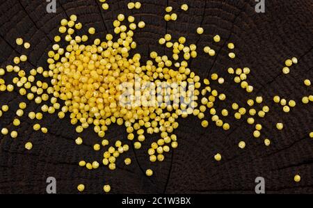 Mucchio di groats del miglio su sfondo nero di legno. Vista dall'alto Foto Stock