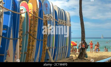 turisti e un certo numero di tavole da surf a noleggio waikiki spiaggia Foto Stock