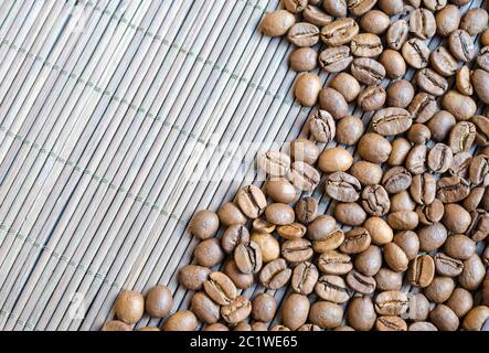 Chicchi di caffè con sfondo di bambù Foto Stock