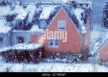 Vista attraverso una finestra con acqua di condensa e pioggia scende al di sotto di una casa in inverno, Witten, Germania Foto Stock