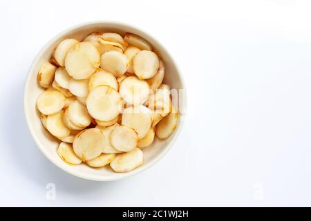 Fette di galangal fresche in ciotola bianca isolate su sfondo bianco. Foto Stock