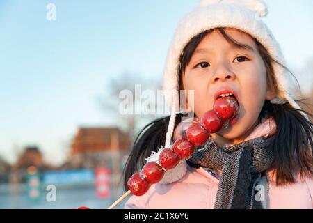Felice bambina mangiare zucchero-rivestito bacche Foto Stock