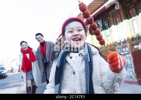 Felice bambina mangiare zucchero-rivestito bacche Foto Stock