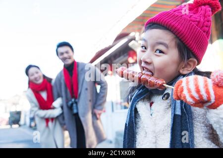 Felice bambina mangiare zucchero-rivestito bacche Foto Stock