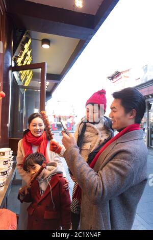 Buona famiglia con lo shopping di frutti di bosco ricoperti di zucchero Foto Stock