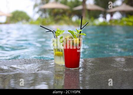 Cocktail classico e mojito di fragola ai bordi della piscina di un resort Foto Stock