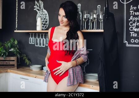 Brunette aspettano di bambino e godendo della maternità Foto Stock