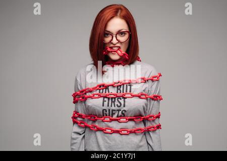 Ragazza impigliate in una catena,un i capelli rossi donna con capelli castani cerca di sbarazzarsi della catena Foto Stock