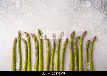 I gambi di asparagi freschi sono allineati su uno sfondo chiaro. Spazio di copia per il testo Foto Stock