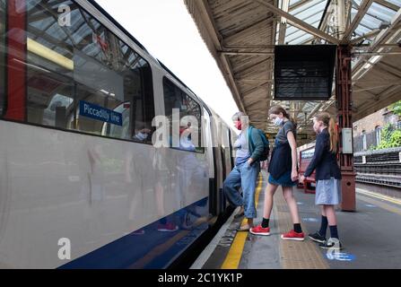 Bambini che indossano maschere per il viso sui mezzi pubblici. Barons Court station. Londra, Regno Unito. 7 giugno 2020. MODULI DI CONSENSO FIRMATI PER TUTTE LE PERSONE IN FOTO Foto Stock