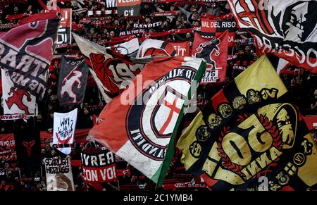 I tifosi dell'AC Milan che salutano e sventolano bandiere allo stadio di calcio San siro, a Milano. Foto Stock