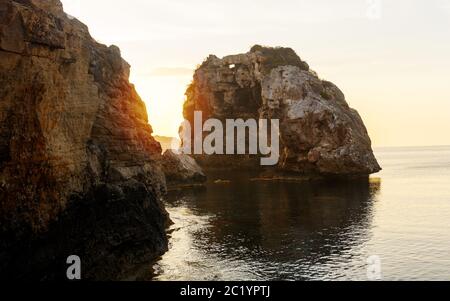 Es Pontas a Maiorca con barca ancorata nelle vicinanze del Mediterraneo. Alba con yacht e arco di roccia vicino Santanyi Maiorca. Foto Stock