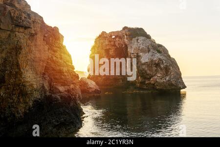 Es Pontas a Maiorca con barca ancorata nelle vicinanze del Mediterraneo. Alba con yacht e arco di roccia vicino Santanyi Maiorca. Foto Stock