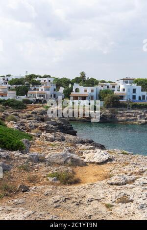 Punta rocciosa con ville private sopra il mare azzurro calmo sull'isola delle Baleari. Isola di Maiorca di acque cristalline e incredibili per nuotare. Foto Stock