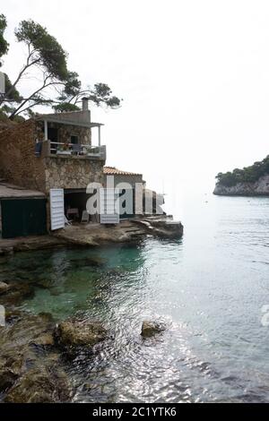 Punta rocciosa con ville private sopra il mare azzurro calmo sull'isola delle Baleari. Isola di Maiorca di acque cristalline e incredibili per nuotare. Foto Stock