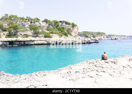 Punta rocciosa con ville private sopra il mare azzurro calmo sull'isola delle Baleari. Isola di Maiorca di acque cristalline e incredibili per nuotare. Foto Stock