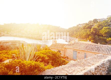 Punta rocciosa con ville private sopra il mare azzurro calmo sull'isola delle Baleari. Isola di Maiorca di acque cristalline e incredibili per nuotare. Foto Stock