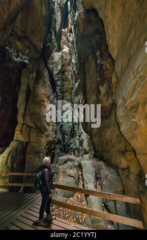 Donna anziana escursionista all'interno del canyon slot a Adršpach Rocks, Adršpach-Teplice Rocks National Nature Reserve, Sudete centrali, Repubblica Ceca Foto Stock