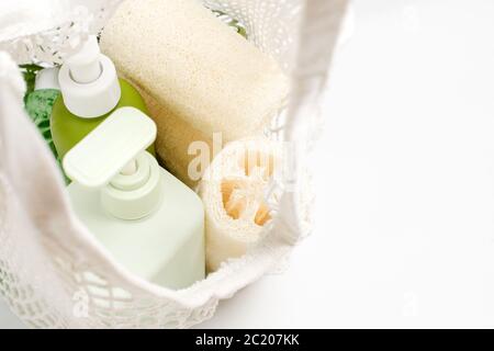 Contenitore verde per shampoo, balsamo o sapone liquido in sacchetto eco. Panno per lavaggi in loofah o luffa, spugna vegetale, alternativa alla plastica, senza sprechi Foto Stock