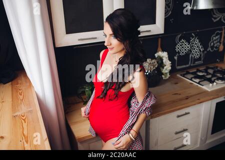 Brunette aspettano di bambino e godendo della maternità Foto Stock