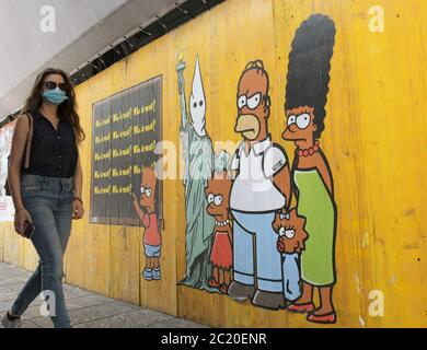 Milano, Italia. 16 Giugno 2020. Italia, Milano Alexandro Palombo Street artist nuovi murales a Milano dal titolo 'solo perché sono Nero' in memoria della morte di George Floyd che rappresenta la famiglia Simpson con pelle nera e accanto alla statua della libertà con il cappuccio del Ku Klux Klan nella foto: Lavora con i Simpsons e ritratto di George Floyd Credit: Independent Photo Agency/Alamy Live News Foto Stock