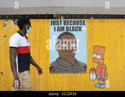 Milano, Italia. 16 Giugno 2020. Italia, Milano Alexandro Palombo Street artist nuovi murales a Milano dal titolo 'solo perché sono Nero' in memoria della morte di George Floyd che rappresenta la famiglia Simpson con pelle nera e accanto alla statua della libertà con il cappuccio del Ku Klux Klan nella foto: Lavora con i Simpsons e ritratto di George Floyd Credit: Independent Photo Agency/Alamy Live News Foto Stock