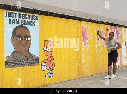 Milano, Italia. 16 Giugno 2020. Italia, Milano Alexandro Palombo Street artist nuovi murales a Milano dal titolo 'solo perché sono Nero' in memoria della morte di George Floyd che rappresenta la famiglia Simpson con pelle nera e accanto alla statua della libertà con il cappuccio del Ku Klux Klan nella foto: Lavora con i Simpsons e ritratto di George Floyd Credit: Independent Photo Agency/Alamy Live News Foto Stock