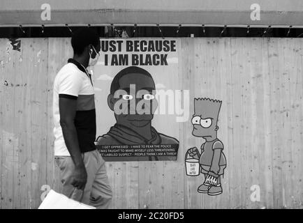 Milano, Italia. 16 Giugno 2020. Italia, Milano Alexandro Palombo Street artist nuovi murales a Milano dal titolo 'solo perché sono Nero' in memoria della morte di George Floyd che rappresenta la famiglia Simpson con pelle nera e accanto alla statua della libertà con il cappuccio del Ku Klux Klan nella foto: Lavora con i Simpsons e ritratto di George Floyd Credit: Independent Photo Agency/Alamy Live News Foto Stock