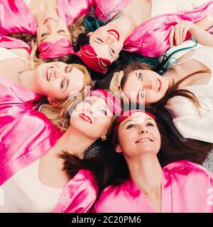 Ritratto di belle ragazze in rosa accappatoi celebrando doccia nuziale. Foto Stock