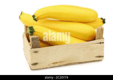 zucchine gialle in una cassa di legno su sfondo bianco Foto Stock