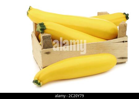 zucchine gialle in una cassa di legno su sfondo bianco Foto Stock