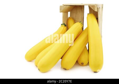 zucchine gialle in una cassa di legno su sfondo bianco Foto Stock