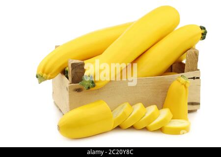 zucchine gialle in una cassa di legno su sfondo bianco Foto Stock