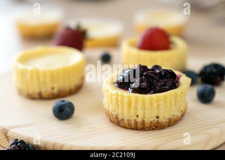 Mini cheesecake decorata con mirtillo, mora e fragola Foto Stock