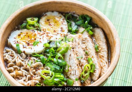 Ciotola di zuppa di ramen di pollo sul tavolo di legno Foto Stock