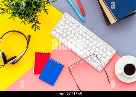 Concetto di scuola online di formazione. Cancelleria con colorata scrivania da ufficio, vista dall'alto Foto Stock