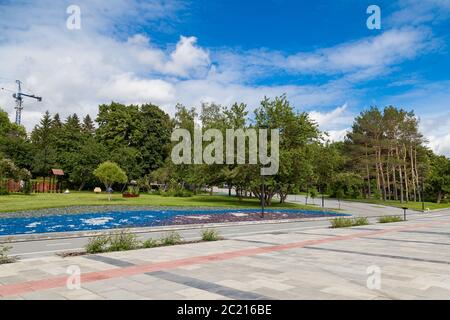 Raffinazione e disposizione della zona parco del lungomare della città con piastrelle lastricate marciapiede, aiuole in pietra di diversi colori su uno sfondo Foto Stock