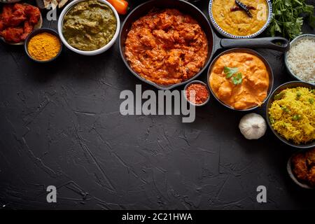 Composizione della cucina indiana in ciotole di ceramica su tavola di pietra nera Foto Stock