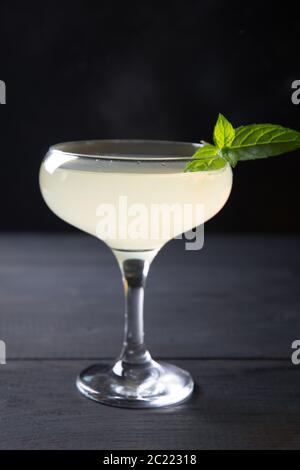Freschezza e cocktail di agrumi in bicchiere di vino isolato al buio. Foto Stock