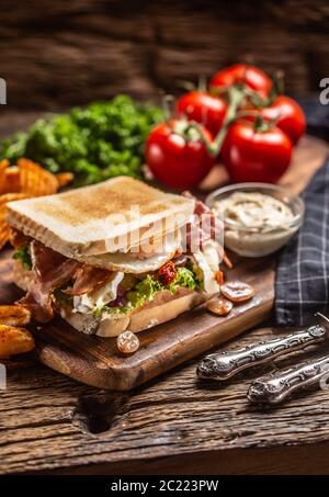 Pancetta e soleggiato lato su uovo toast alla griglia con spicchi di patate piccanti e salsa sul lato Foto Stock