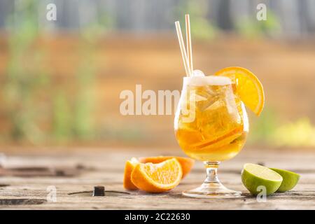 Limonata di birra con arancia e ghiaccio su un tavolo da giardino durante una calda giornata estiva Foto Stock