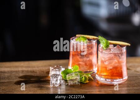 Limonata di mirtilli rossi in due bicchieri con ghiaccio su sfondo scuro Foto Stock