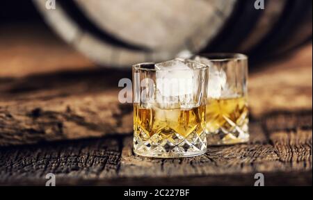 Whisky su ghiaccio in un ambiente rustico di legno scuro Foto Stock