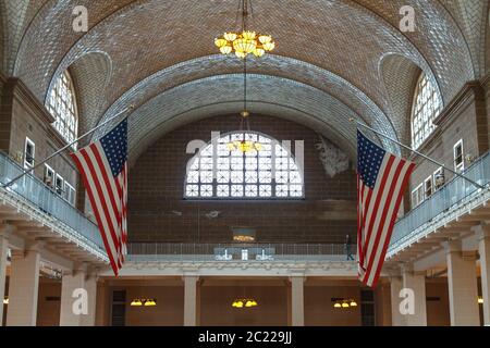 Due bandiere americane sospese nella sala del Registro di Ellis Island Foto Stock